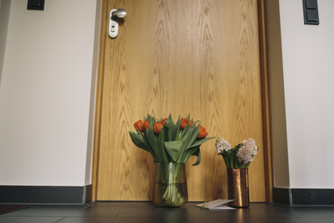 Farewell flowers, candle and condolende card at apartment door of deceased neighbour stock photo