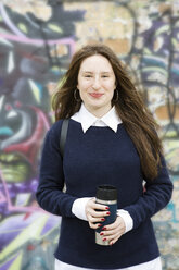 Deutschland, Berlin, Porträt eines lächelnden Teenagers vor einem Graffiti - OJF00228