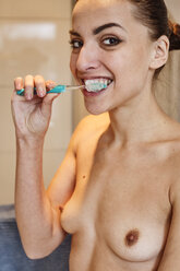 Portrait of nude young woman brushing teeth - JATF01026