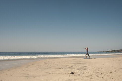 Junge Frau übt Yoga am Strand - ABAF02202