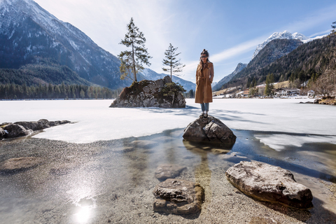 Germany, Bavaria, Ramsau, young woman standing on stone, Hintersee stock photo