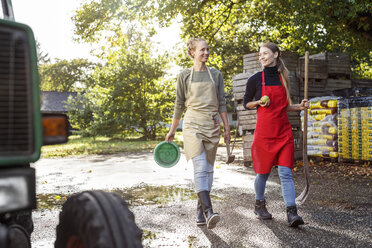 Zwei lächelnde Frauen bei der Arbeit auf einem Bauernhof - PESF00897