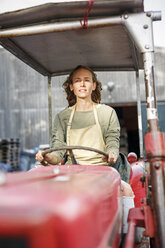 Porträt einer selbstbewussten Frau, die einen Traktor fährt - PESF00900