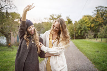 Two happy women walking in rural landscape - PESF00911