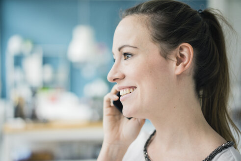 Porträt einer glücklichen Frau am Telefon, Nahaufnahme - MOEF00710