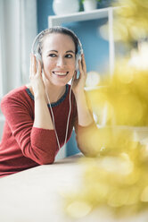 Portrait of happy woman with listening music with headphones - MOEF00725