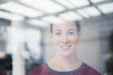 Portrait of smiling woman looking out of window - MOEF00730