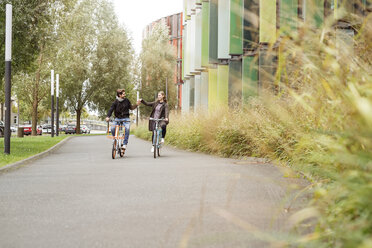 Glückliches Paar beim Fahrradfahren auf einer Fahrspur - PESF00915