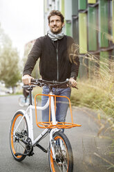 Lächelnder Mann mit Fahrrad auf einer Fahrspur - PESF00918