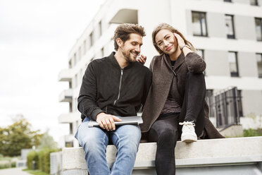 Happy couple with laptop in urban surrounding - PESF00932