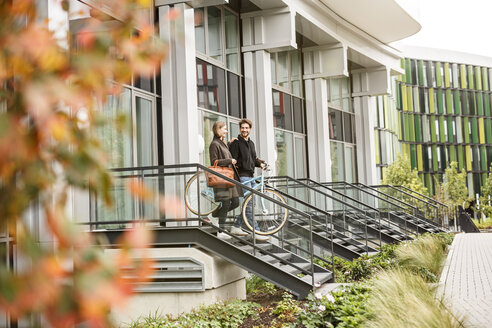 Smiling couple leaving house with bicycles - PESF00933