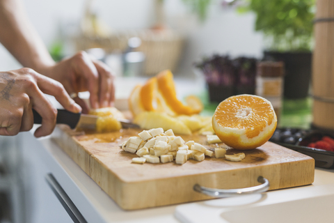 Frau bereitet Obst auf einem Schneidebrett vor, lizenzfreies Stockfoto