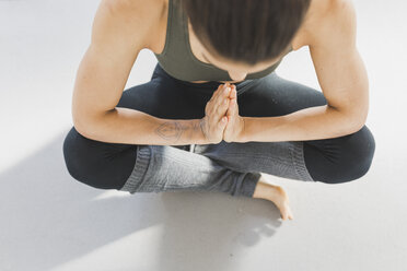Blick von oben auf eine Frau, die auf dem Boden sitzt und Yoga praktiziert - ASCF00813