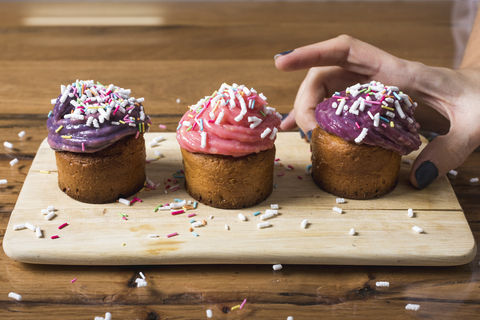 Frau nimmt Muffin, lizenzfreies Stockfoto