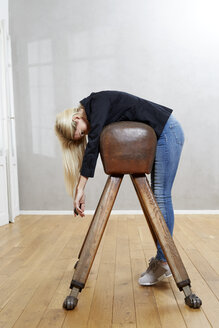 Woman leaning on pommel horse - FMKF04749