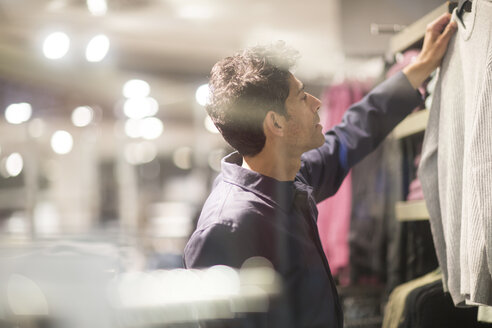 Mann wählt Kleidung in einem Geschäft aus - SGF02162