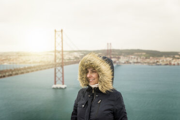 Portugal, Lisbon, portrait of happy woman in front of Ponte 25 de Abril - EPF00483