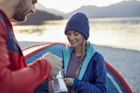 Young couple at tent having coffee break - PNEF00428