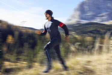 Man running fast on mountain trail - PNEF00435