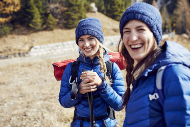 Zwei lachende junge Frauen beim Wandern in den Bergen - PNEF00444