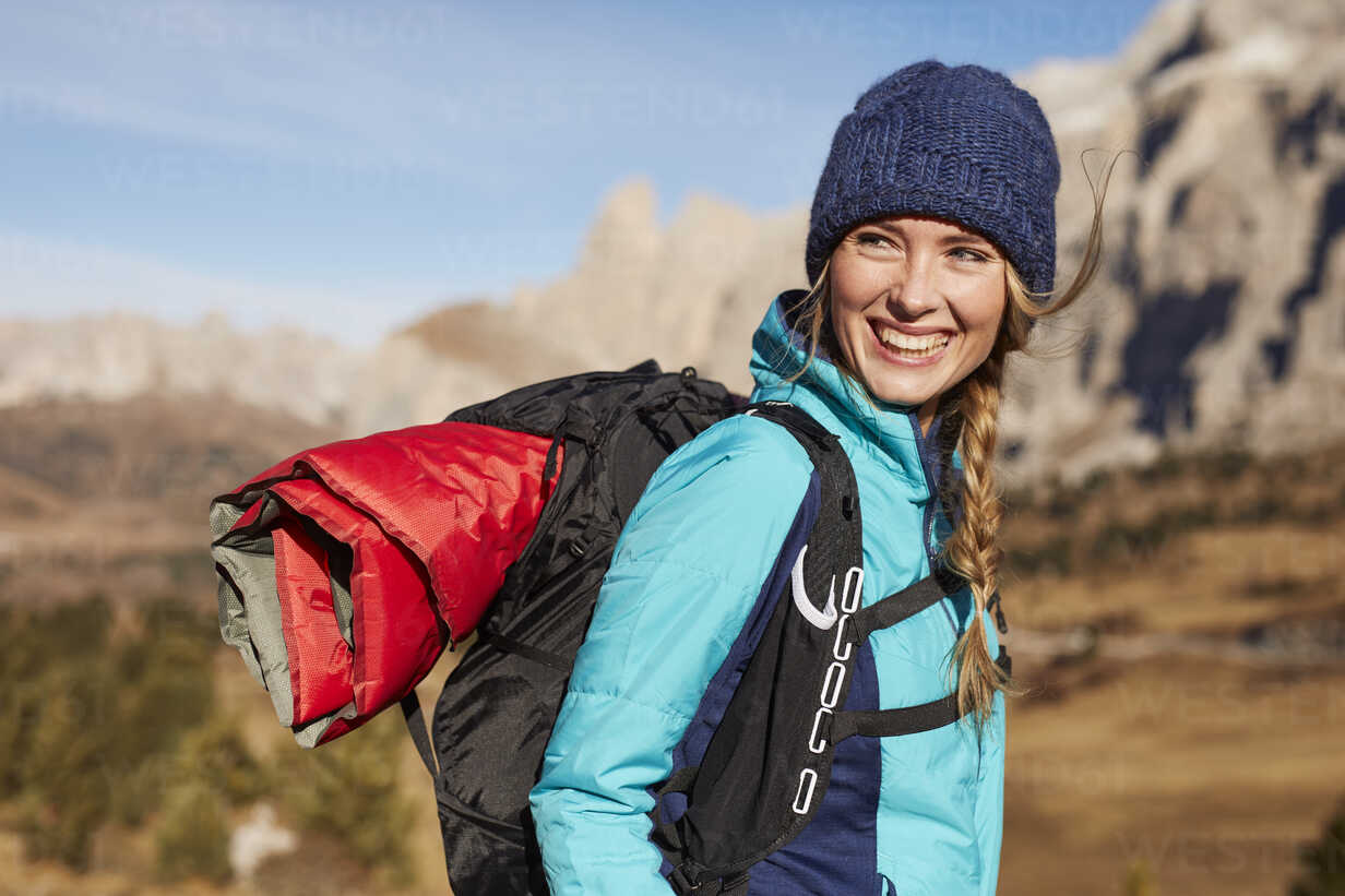 Portrait of happy young woman hiking in the mountains stock photo