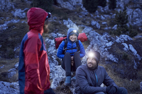 Smiling mountaineers wearing headlamps in the mountains at dusk - PNEF00458