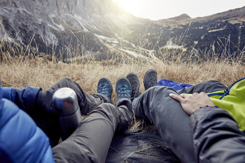 Legs of couple sitting in tent in the mountains - PNEF00469