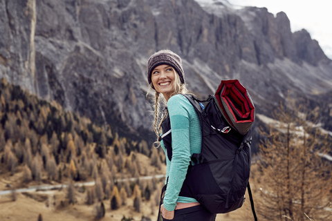 Portrait of happy young woman hiking in the mountains stock photo