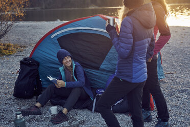 Group of hikers camping at lakeshore at sunset - PNEF00506