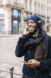 Afroamerikanischer Mann mit Smartphone und Headpone - MAUF01300
