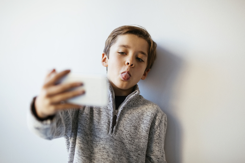 Boy taking selfie sticking out tongue stock photo