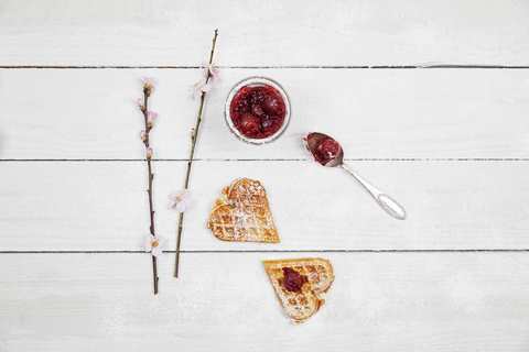 homemade waffels with cherries, waffel hearts with cherry blossom decoration stock photo