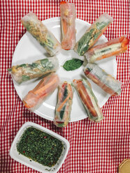 vegan vietnamese springrolls, filled with bell pepper,carrots,cucumber,mint,cilantro,roasted peanuts,roasted onions and spring onions with spicy dip - IPF00437