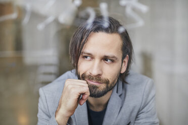 Portrait of bearded businessman looking out of window - PNEF00515