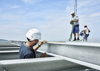 Bauarbeiter bei der Kontrolle eines Stahlträgers - CVF00102