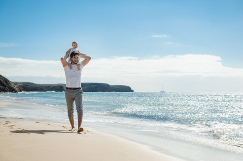 Spanien, Lanzarote, Vater trägt kleine Tochter auf seinen Schultern am Strand - DIGF03226