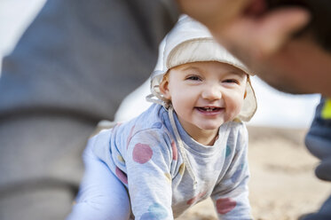 Spain, Lanzarote, portrait of laughing baby girl playing with father on the beach - DIGF03230