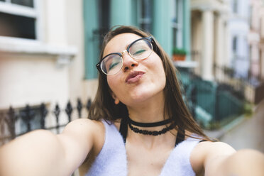 Glückliches Teenager-Mädchen in der Stadt, das ein Selfie macht - WPEF00009
