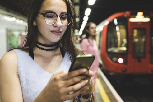 Teenage girl using cell phone at subway station - WPEF00023