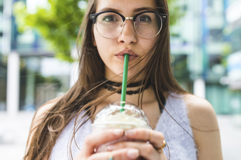 Porträt eines jugendlichen Mädchens, das einen Milchshake trinkt, lizenzfreies Stockfoto