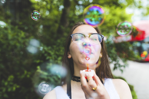 Teenager-Mädchen bläst Seifenblasen im Freien, lizenzfreies Stockfoto