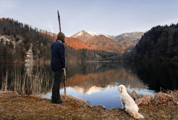 Österreich, St. Gilgen, Krottensee im Herbst, junger Mann mit Hund - WVF00923