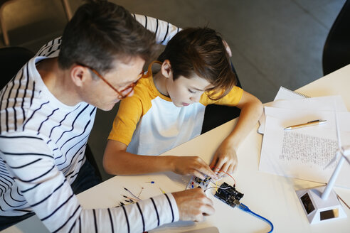 Vater und Sohn beim Zusammenbau eines Baukastens mit einem Windradmodell - EBSF02130