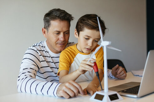 Vater und Sohn mit Laptop beim Zusammenbau eines Windradmodells - EBSF02137