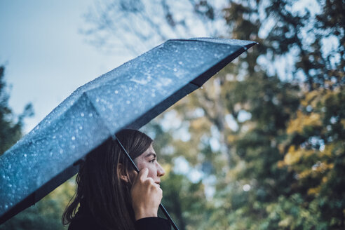 Junge Frau mit nassem Regenschirm im herbstlichen Park - JSCF00034