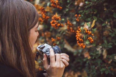 Young woman taking photos with old camera in autumnal nature - JSCF00041