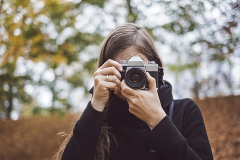 Portrait of young woman taking photos in autumn stock photo