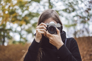 Portrait of young woman taking photos in autumn - JSCF00043