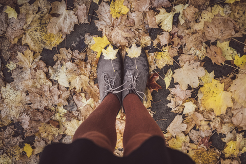 Junge Frau macht Selfie von ihren Beinen im Herbst, Teilansicht, lizenzfreies Stockfoto