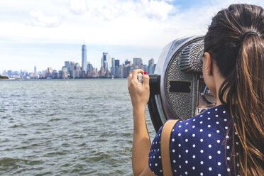 USA, New York, Frau betrachtet die Skyline von Manhattan mit einem münzbetätigten Fernglas - WPEF00044